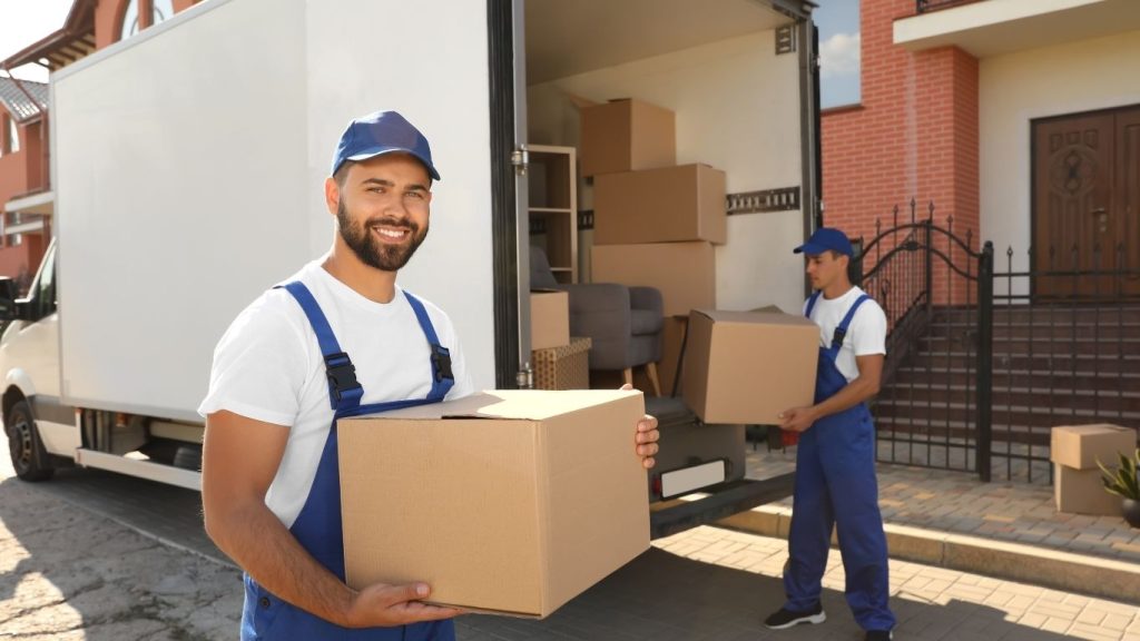 Homens carregando mudança para caminhão.