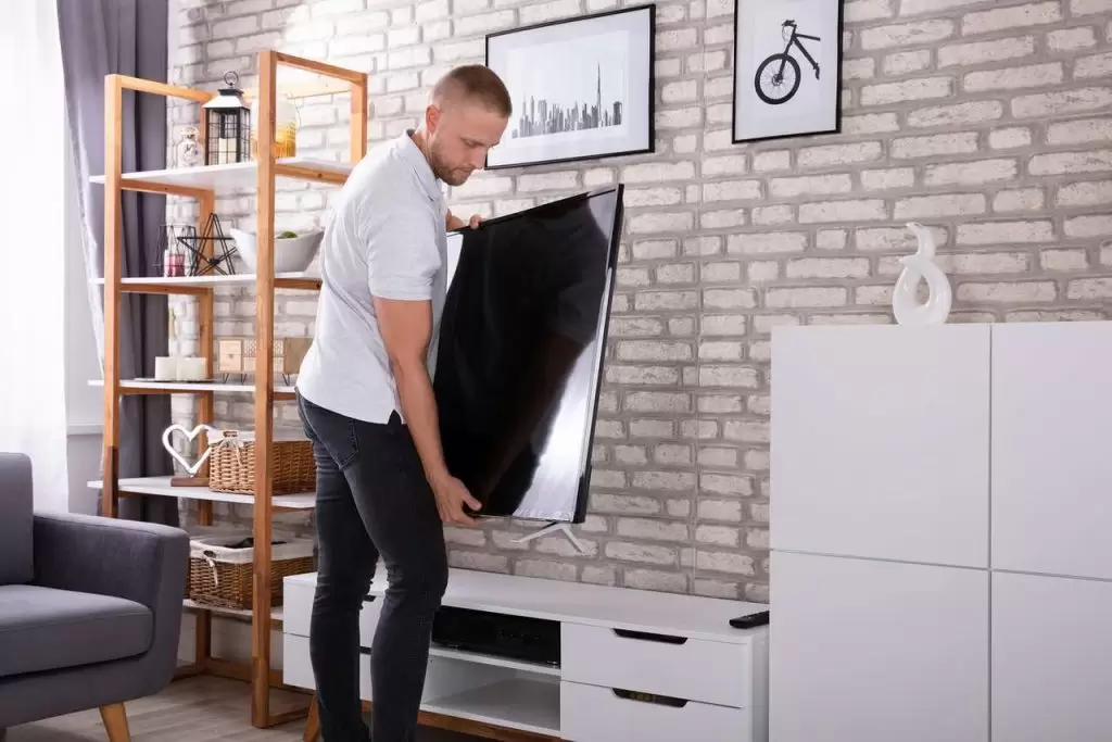 homem instalando TV na parede