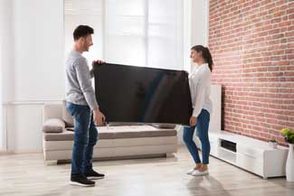 como transportar TV: casal carregando TV