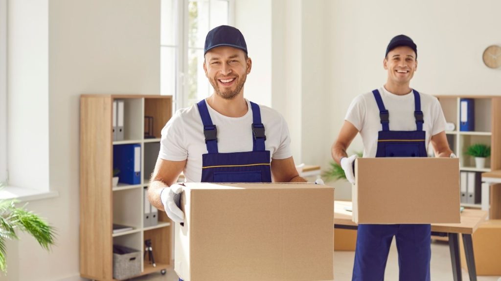 Dois homens carregando caixas com mudança.