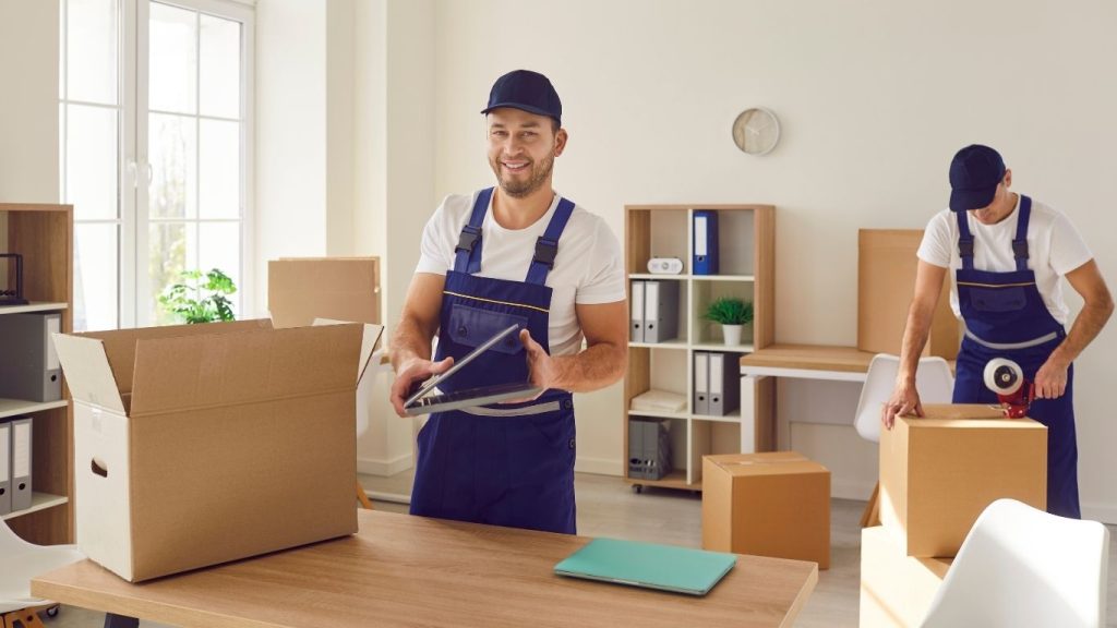 Funcionários de empresa de mudança embalando mudanças de cliente.