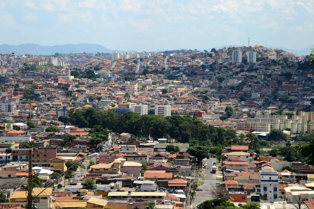 Foto aérea mostrando o bairro com as residências e mata.