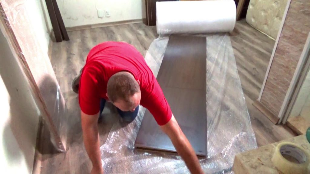 Homem colocando parte de armário em plástico bolha.